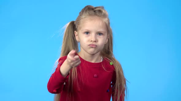 Little Girl Looking at Camera, Threatening with Finger To Someone.