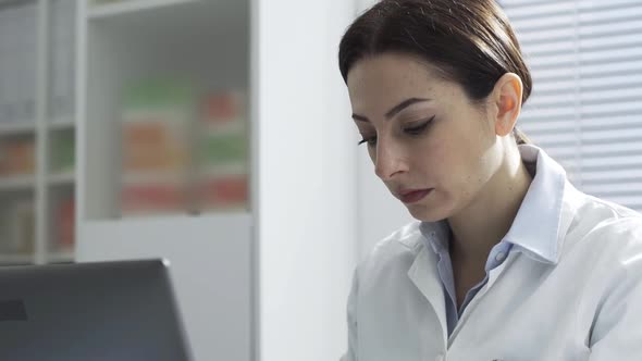 Female doctor working with a laptop in her office