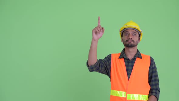 Young Bearded Persian Man Construction Worker Thinking While Pointing Up