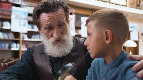 Teen Schoolboy Carefully Listening His Senior Respected Grandfather Telling about Books
