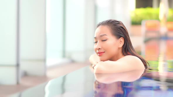 Young asian woman enjoy around outdoor swimming pool for leisure