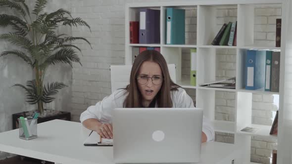 Young Woman Doctor Looking at Laptop. Facial Expression of Shock