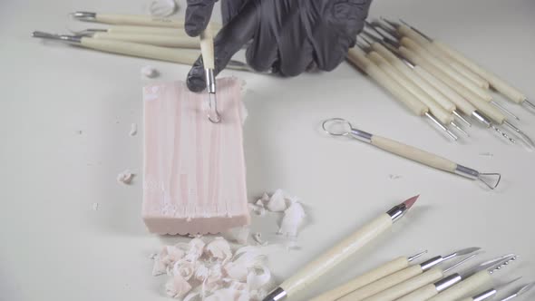 Artist uses a ribbon tool on a piece of plasticine 4k
