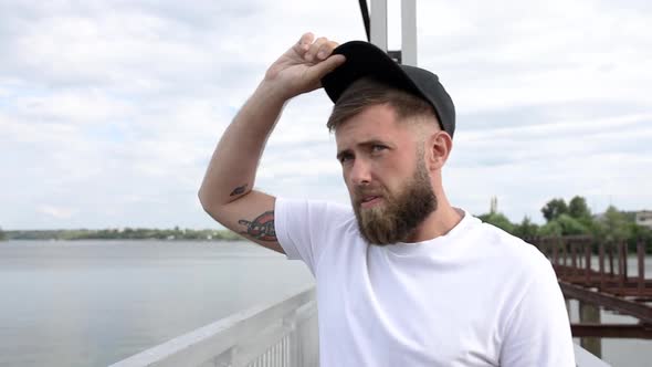 A young guy walks across the bridge