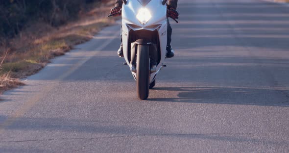 Man riding on a white sports motorcycle in a curvy highway
