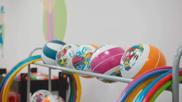 Balls and Hula Hoops on Rack in Hall for Children Gymnastics