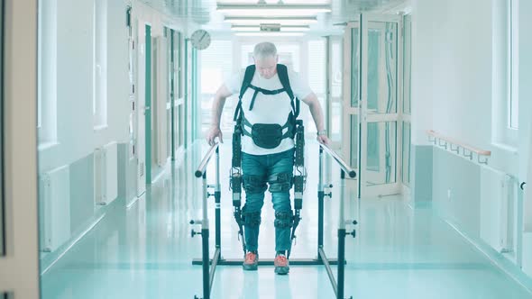 A Man is Using Exosuit to Practice Walking in the Hospital