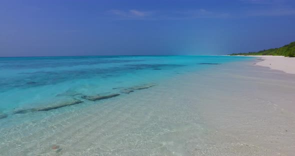 Daytime overhead island view of a sandy white paradise beach and blue water background in colourful 