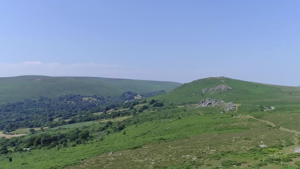 Wide shot aerial tracking forward towards Bonehill rocks, near widecombe on the moor. Dartmoor, Engl