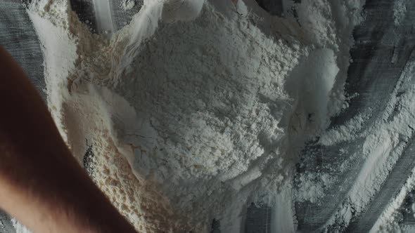 Man Piling Flour into Mound with Well in Center