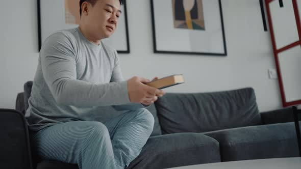 Confident Asian man reading book