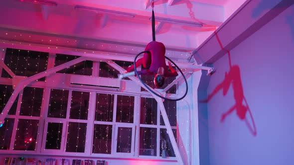 Aerial Gymnast Performs Beautiful Dance Number on the Ring in Pink Neon Lighting