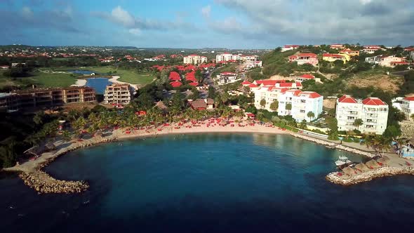 Aerial view dolly in tilt down of Curacao's Blue Bay beach, Dutch Caribbean island, golf resort