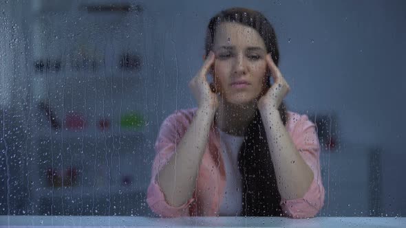 Exhausted Woman Suffering From Head Ache Behind Rainy Window, Migraine Disorder