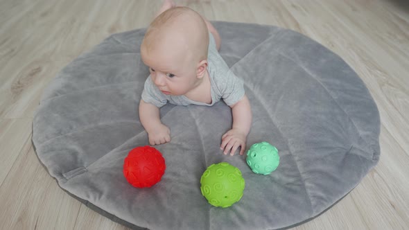 Cute Baby Lying on His Tummy on Play Mat 3 Month Old Newborn Infant Boy Playing with Colorful