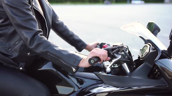Female Biker in Stylish Leather Clothes Sitting on Black Sporty Motorbike