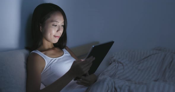 Woman using tablet computer at home in the evening 