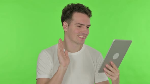 Video Call on Tablet By Young Man on Green Background