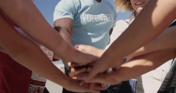 Volunteers forming hand stack on the beach 4k