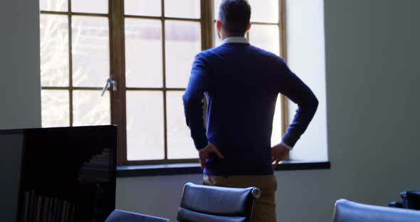 Executive looking through window in office