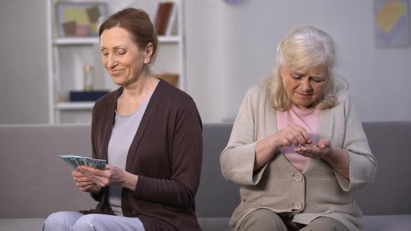 Old Woman Counting Coins Looking at Happy Mature Daughter Calculating Dollars