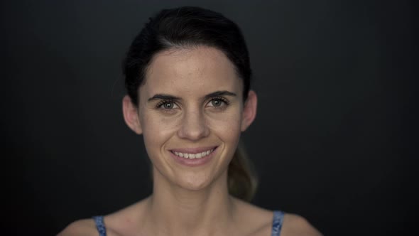 Woman smiling cheerfully and then looking up in thought