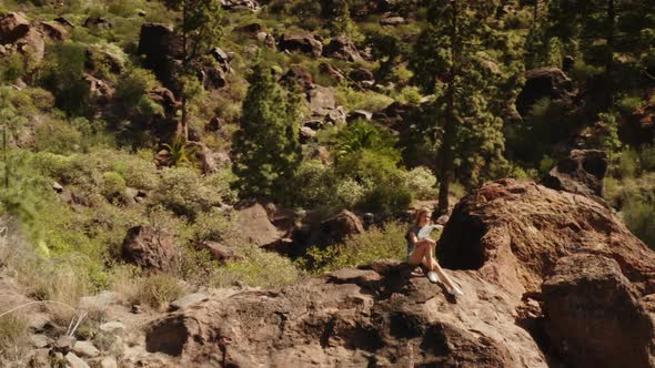 Gorgeous Woman Sitting on Top of a Rock Enjoying the Scenery