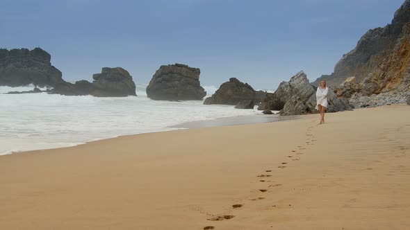 Sexy Woman Walks Over a Sandy Beach at the Ocean  Extreme Slow Motion