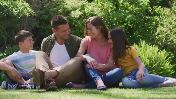 Caucasian family smiling while sitting together in the garden