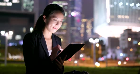 Businesswoman use of tablet computer at night