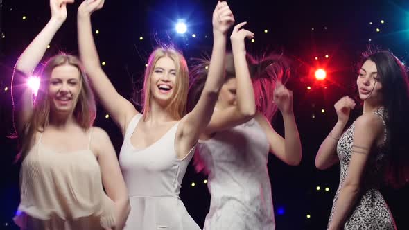 Four Girls Dancing Together and Blowing Kisses in a Disco