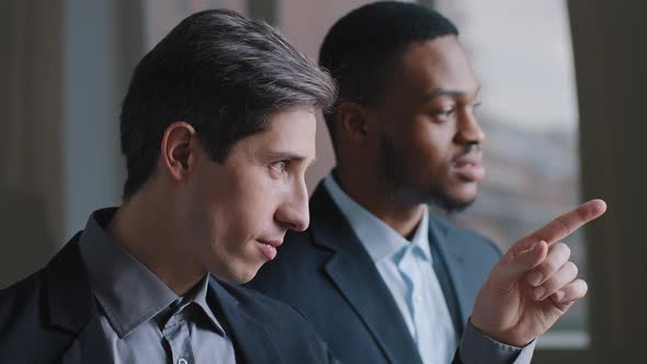 Closeup Two Multiracial Businessmen Colleagues Stand in Office Near Window Contemplate Dreaming