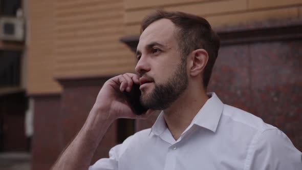 Close Up Man's Face Talks and Holds Phone