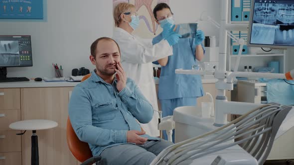 Dentistry Patient Expressing Serious Toothache in Oral Care Cabinet