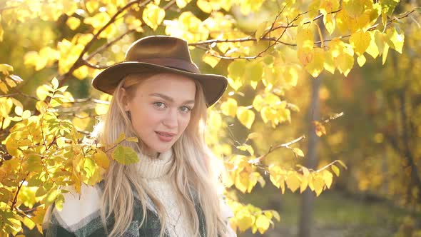 Portrait of Gorgeous Caucasian Woman Posing at Sunny Autumn Day Outdoors.