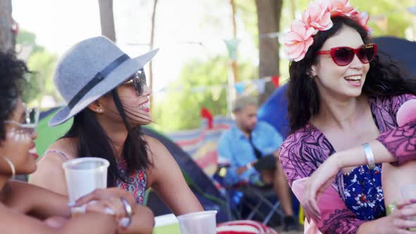 Female friends interacting with each other at music festival 4k