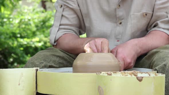 Male Potter of Caucasian Ethnicity Makes a Brown Clay Pot Moistens Clay and Draws a Mold