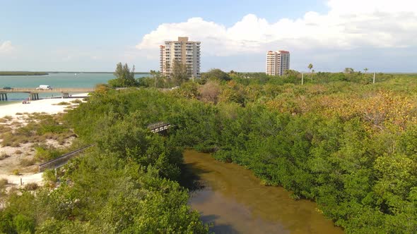 Fly over mangroves revealing hotels and main highway in Lovers key, Florida