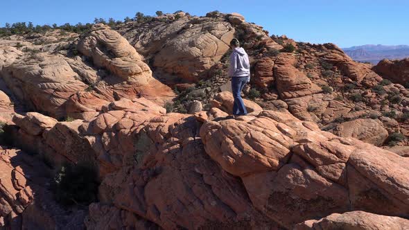 Woman hiking over rocky desert terrain in the desert