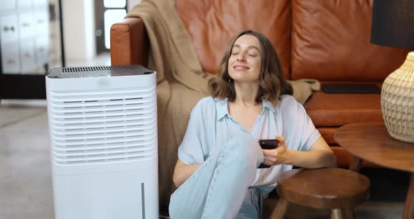 Woman with Air Purifier or Conditioner at Home