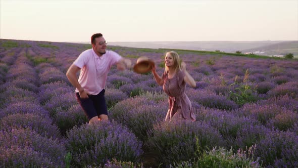 Young Couple Jumping Up in Flowering Lavender Field