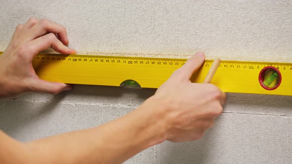 Man Builder Using Balance Ruler and Drawing Line Closeup