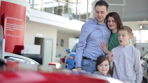 Happy family with a dealer, buying a new electric car