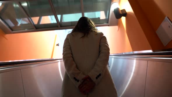 Point of View View From the Back of a Woman Riding the Escalator Up To the Floor of the Shopping