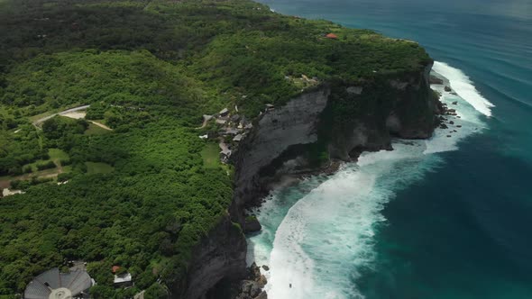 drone view of the famous cliffs in uluwatu. Island of Bali, indonesia. The land is covered by green