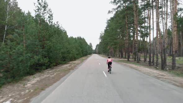 Cyclist cycling in cycling apparel and helmet on bicycle. Cycling in forest.
