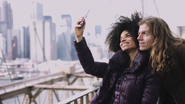 Couple taking selfie on brooklyn bridge with smart phone