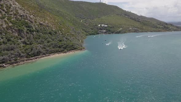 Aerial: waterskier enjoys Knysna Lagoon on sunny summer day in Africa