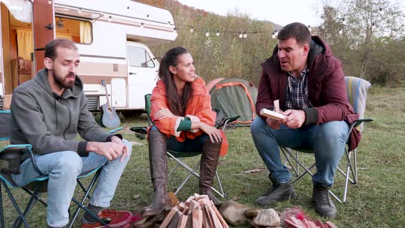 Caucasian Friends Relaxing Together in Front of Their Camper Van