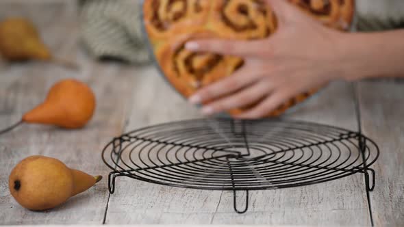 Female Hands Take Out Pear Buns From the Glass Mold and Putting on Cooling Rack